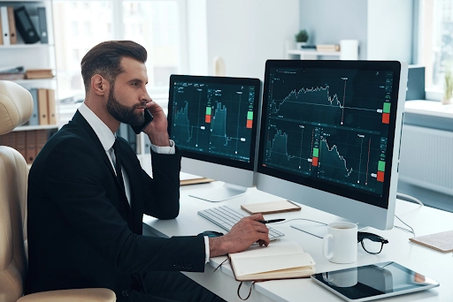 businessman analyzing data on the stock market and talking on the phone in the office