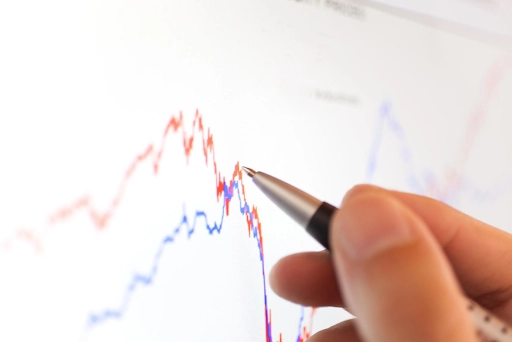 man using pen to analyze on pair trading charts