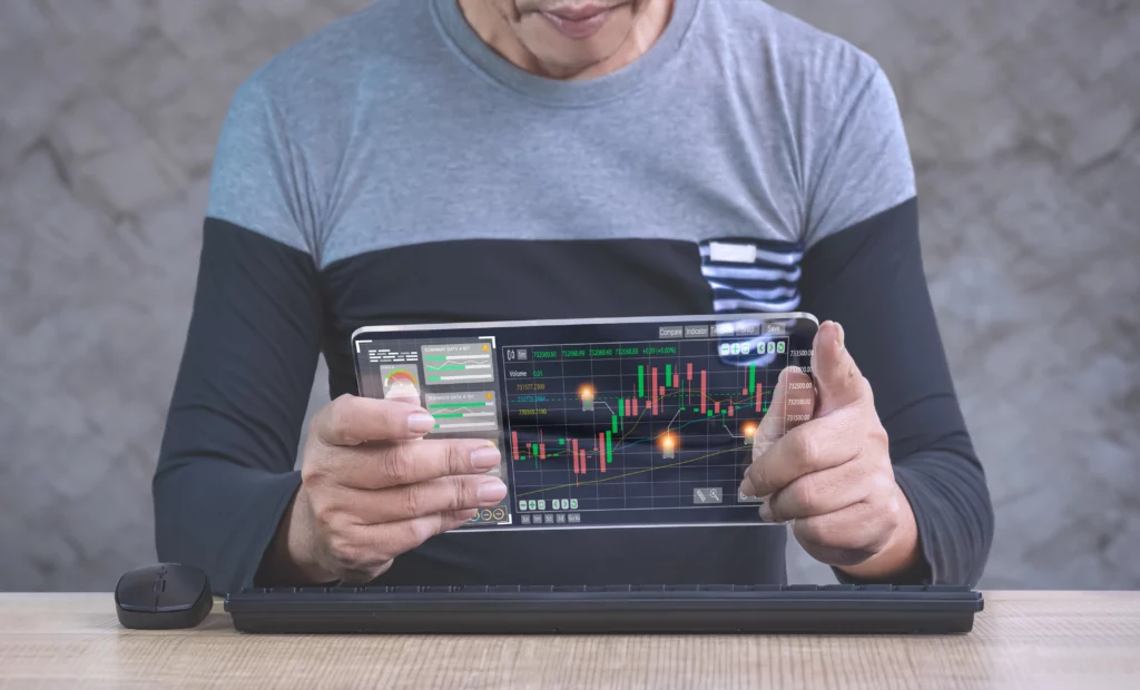 trader using transparent tablet device to analyse forex trading chart