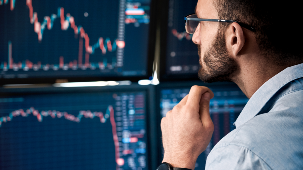 man looking at multiple screen monitors