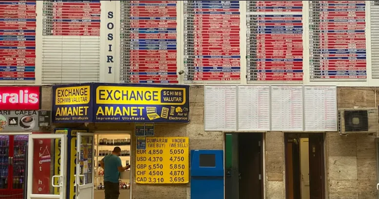 Currency exchange bureau displaying exchange rates on large boards.