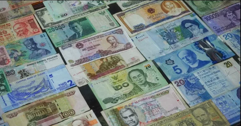 Banknotes from different countries arranged in rows.