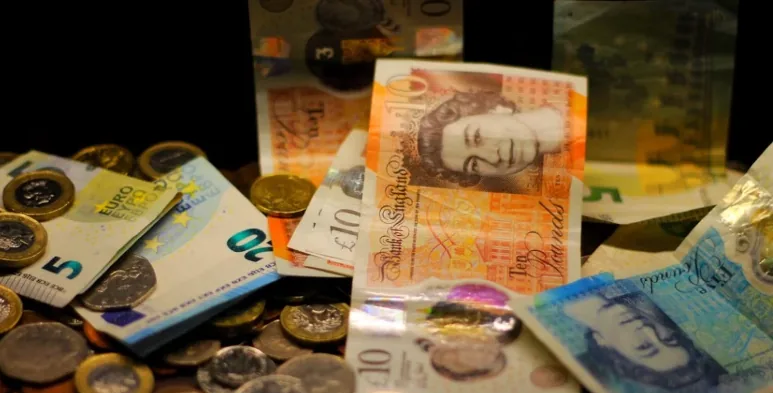 British pound banknotes and coins alongside other currencies.